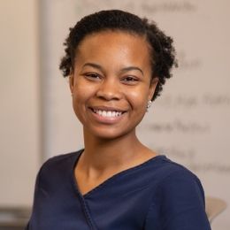 Female dental hygiene student smiles while posing in the library.